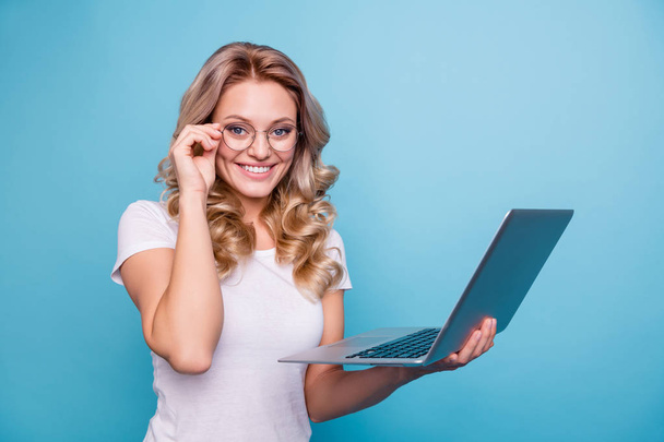 Portrait of her she nice-looking lovely winsome attractive cheerful cheery wavy-haired lady in casual white t-shirt holding in hand laptop isolated on blue pastel background - Φωτογραφία, εικόνα