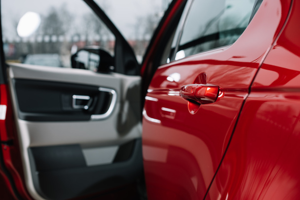 foco selectivo de la puerta brillante del coche del automóvil rojo
  - Foto, imagen