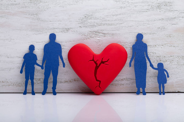 Broken Heart Between Cutout Blue Family Against White Textured Background - Photo, Image