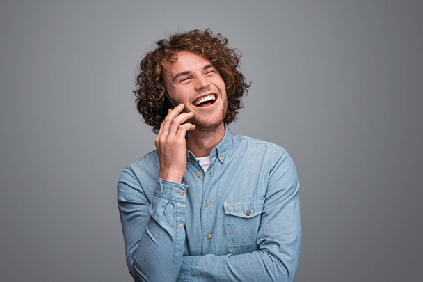 Cheerful male speaking on smartphone - Foto, afbeelding