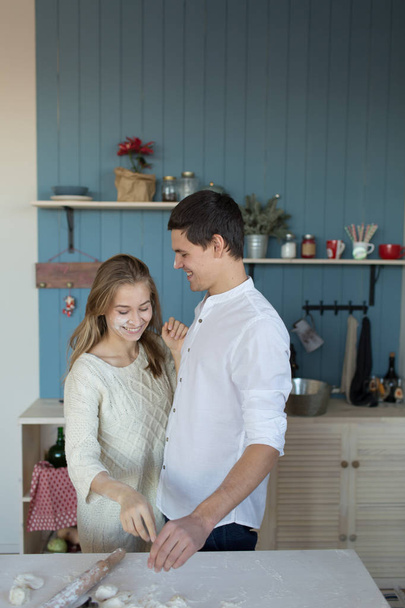 young couple the husband and the wife in pajamas making breakfast and having fun in kitchen. - Foto, Bild