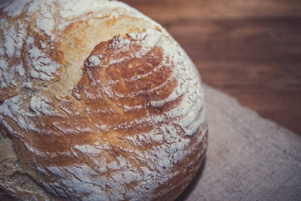 Świeżo upieczony chleb na drewnianym tle - Zdjęcie, obraz