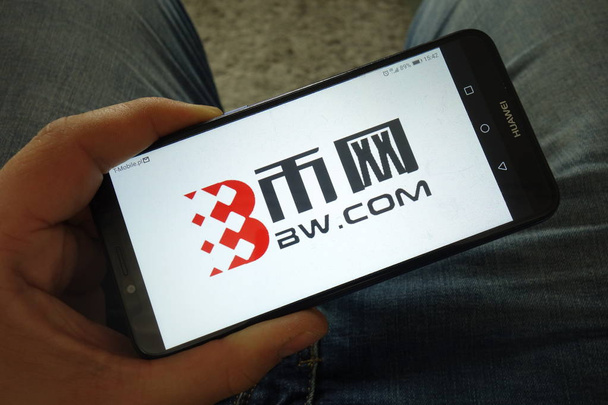 KONSKIE, POLAND - March 31, 2019: Man holding smartphone with BW.com cryptocurrency exchange logo - Foto, immagini