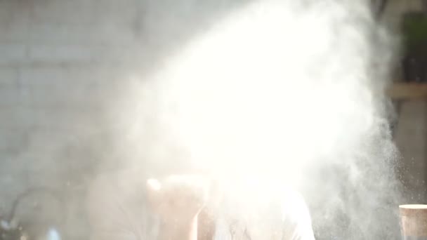Portrait of young woman blowing flour from hand right to the camera. Doing air kiss. Smiling and looking at the camera. Slowmotion. - Video, Çekim