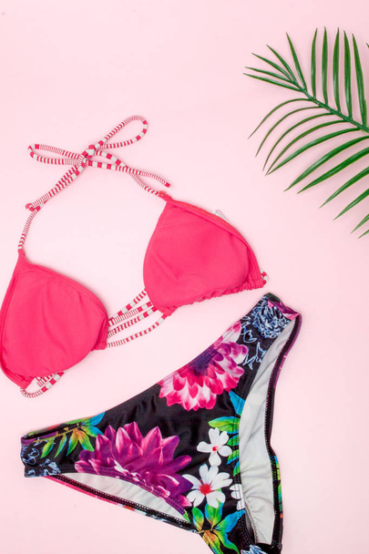 Hat, swimsuit and sunglasses on pink background. Top view, flat lay, space for text - Φωτογραφία, εικόνα