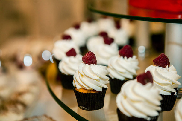 Delicious cupcakes with berries on festive table close up - 写真・画像
