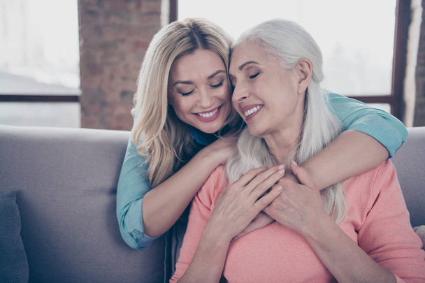 Close up photo two amazing she her ladies mom granddaughter child granny grandmother hugging piggy back eyes closed wear casual domestic clothes sit comfy cosy couch divan flat house indoors - Fotoğraf, Görsel