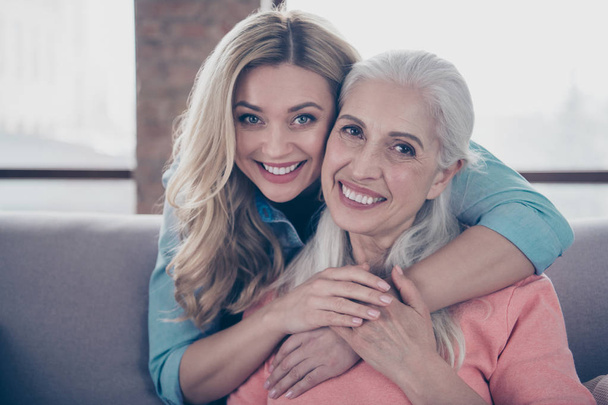 Close up photo two amazing she her ladies mom child granny grandmother hugging piggy back missed wait meeting long time wear casual domestic clothes sit comfy cosy couch divan flat house indoors - Фото, изображение