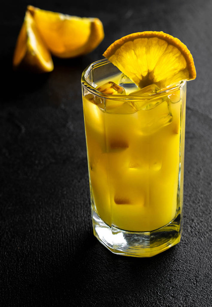 апельсиновый сок со льдом и ломтиками апельсина на черной спине
 - Фото, изображение