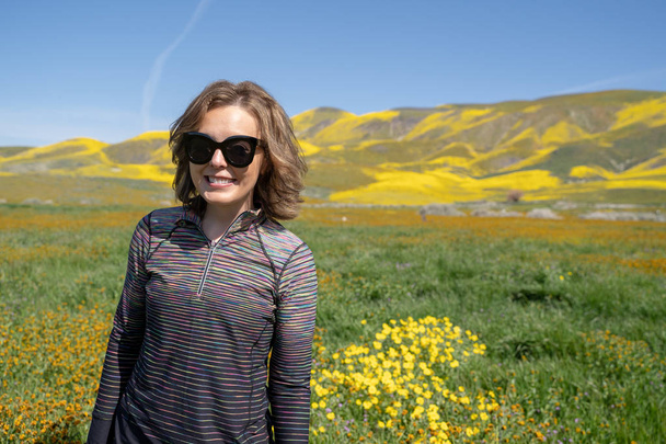 Mladá žena stojící na poli stojí při Super květu na  - Fotografie, Obrázek