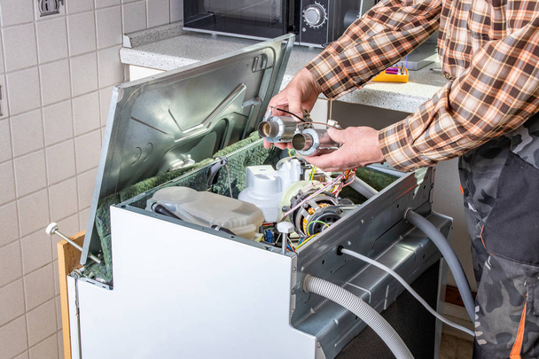 People in technician jobs. Appliance repair technician works on  - Photo, Image
