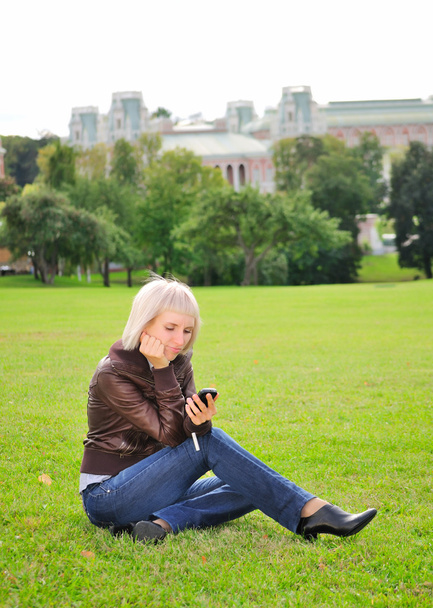 Woman with cellphone in park - Zdjęcie, obraz