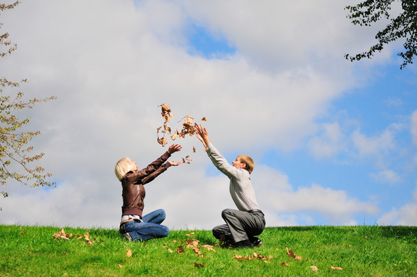 Щаслива пара насолоджується падаючим листям
 - Фото, зображення