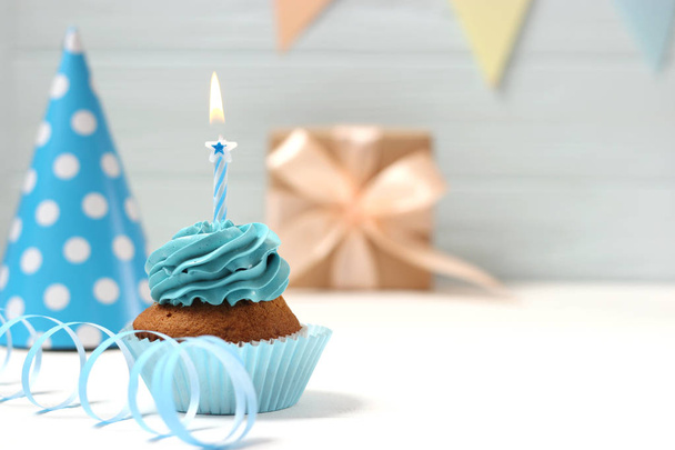 Köstliche Cupcake mit einer Kerze auf einem farbigen Hintergrund mit Platz zum Einfügen von Text. Festlicher Hintergrund, Geburtstag. - Foto, Bild