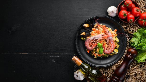 Bulgur with shrimp, mussels and vegetables. On the old background. Top view. Free space for your text. - Fotografie, Obrázek