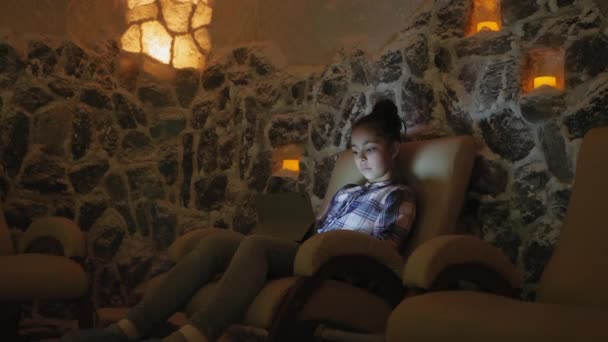 Дівчинки підлітка розслаблюючій в соляна печера в галотерапія - Кадри, відео