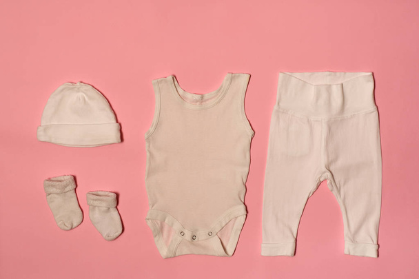 Concept de mode bébé sur fond rose. Casquette, body, pantalon et chaussettes
. - Photo, image