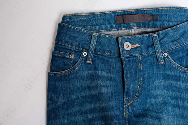 Blue jeans on white wooden background. Fashion concept. Close up - Valokuva, kuva