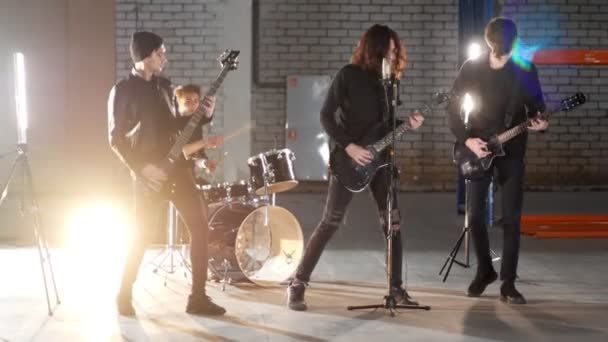 Een rockgroep met een herhaling. Gitaristen in zwarte kleren die hun delen spelen. - Video