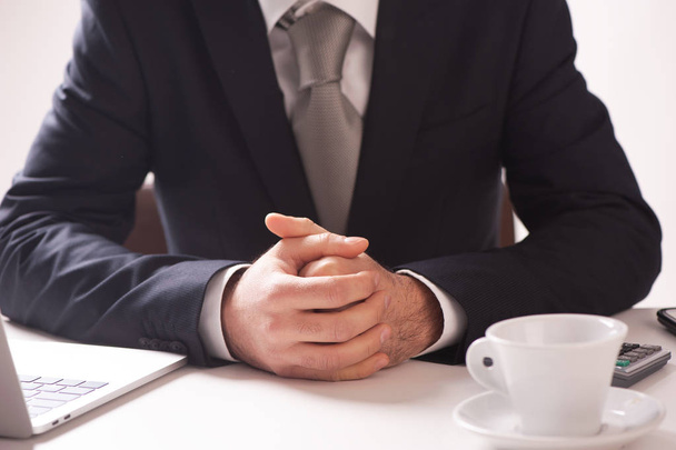 Empresário sentado na mesa com as mãos dobradas
 - Foto, Imagem