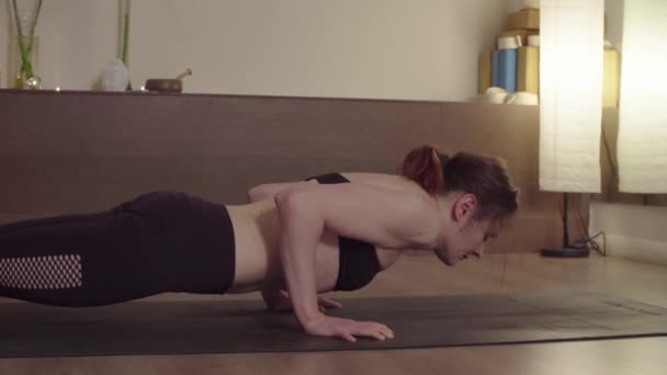 Žena dělá jógu cvičení ve studiu - Chaturanga Dandasana - Záběry, video