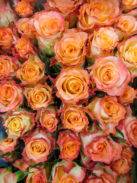 ein Strauß frischer, wunderschöner orangefarbener Rosen in einer Vase. - Foto, Bild