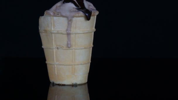 Tající zmrzlina, na které je na černém pozadí omáčka z čokoládového sirupu - Záběry, video