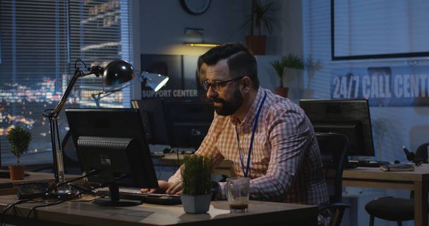 Man working late at night in an office - Photo, Image