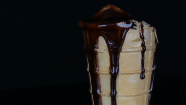Topnienia lodów, na którym nalewa sos czekoladowy syrop na czarnym tle - Materiał filmowy, wideo