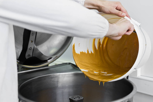Работник заполняет арахисовое масло в промышленных смесителей, пищевой промышленности, с
 - Фото, изображение