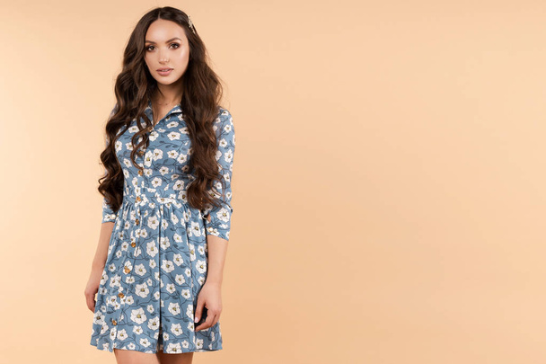 Pretty female in blue floral dress and sneakers smiling - Photo, Image