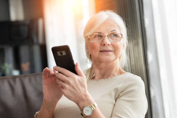 Portrait of elegant senior woman with smart phone - Fotó, kép