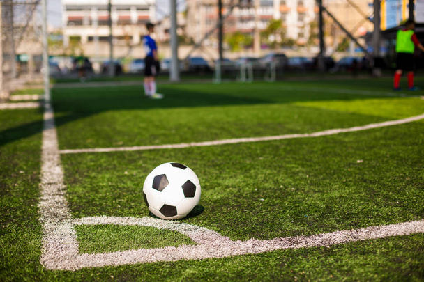 μπάλα ποδοσφαίρου σε πράσινο τεχνητό χλοοτάπητα στη γωνία του γηπέδου ποδοσφαίρου - Φωτογραφία, εικόνα