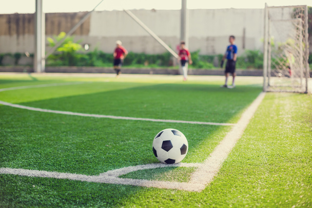 μπάλα ποδοσφαίρου σε πράσινο τεχνητό χλοοτάπητα στη γωνία του γηπέδου ποδοσφαίρου - Φωτογραφία, εικόνα