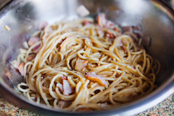 Spagetti sajttal és szalonnával egy fém tálban. közelíti - Fotó, kép