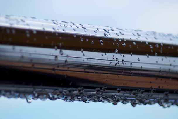 Tubi in acciaio cromato con gocce d'acqua nel porto fluviale dopo la pioggia. - Foto, immagini