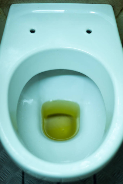 Sporco bagno terribile in un bagno pubblico. Placcatura deteriorata da umidità e urina. Colore giallo urina in bagno, pavimento sporco.  - Foto, immagini