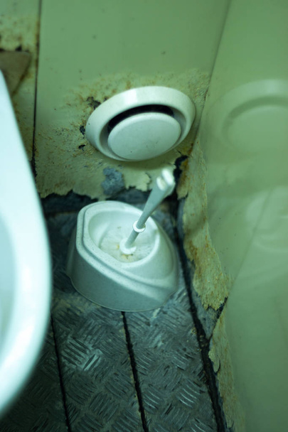 Sporco bagno terribile in un bagno pubblico. Placcatura deteriorata da umidità e urina - Foto, immagini
