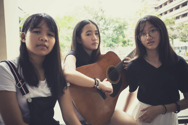 trzy Asian teen z hiszpańskim gitara pozować jak muzyka Marka - Zdjęcie, obraz