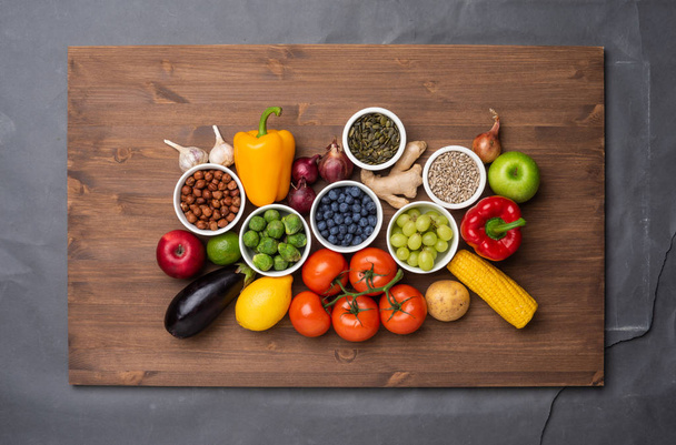 Zdrowe składniki odżywcze: świeże warzywa, owoce i superjedzenie. Odżywianie, dieta, wegańska koncepcja żywności. Kontekst drewniany - Zdjęcie, obraz