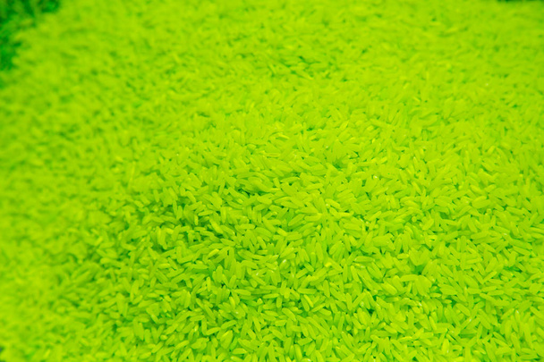 Granos de arroz sin cocer fondo verde fluorescente
 - Foto, imagen