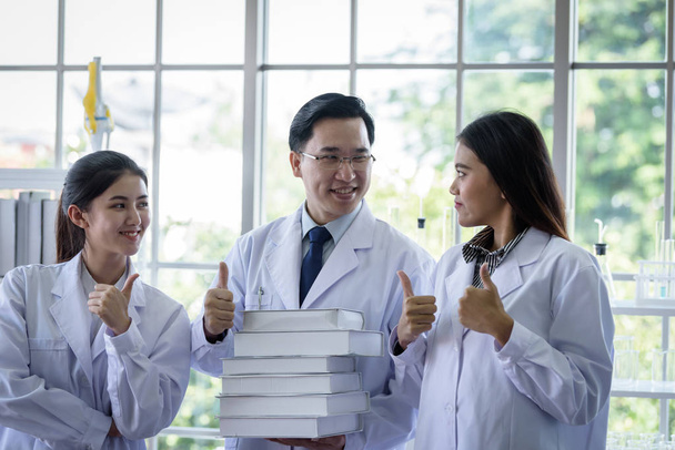 A rangidős ázsiai tudós új munkát adott a laborban tanuló diákoknak. - Fotó, kép