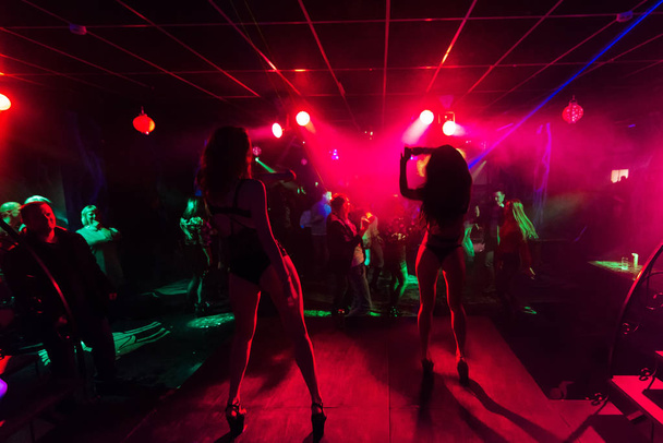 zwei Tänzerinnen tanzen auf der Silhouette der Nachtclubszene - Foto, Bild