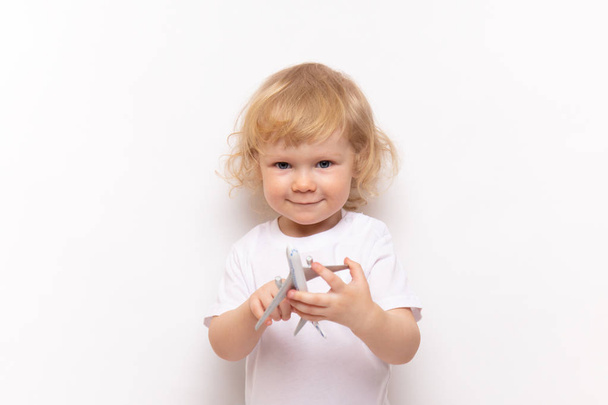 child playing with toy airplane against on a white background. concept dreams of flight - Photo, Image