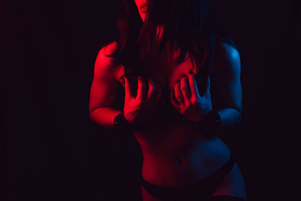 sexy erotische lichaam van een meisje met een mooie slanke figuur in ondergoed in handboeien voor BDSM rol-playing seksuele spelletjes - Foto, afbeelding