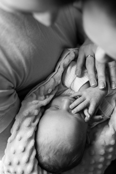 Mulher e homem segurando as mãos de um recém-nascido. Mãe, pai e bebé. O rapaz cobriu a cara com a mão. Feliz vida familiar. O homem nasceu
. - Foto, Imagem