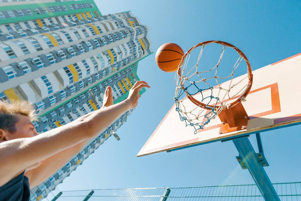 Outdoor portrait street basketball player playing with the ball on sunny day - 写真・画像