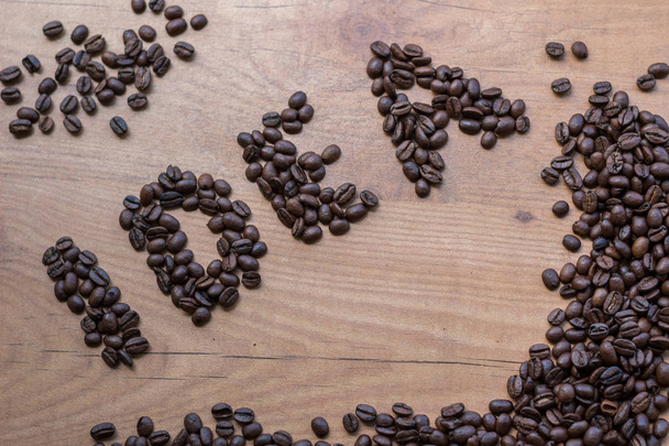 Conceptional sign IDEA drawn among brown roasted beans of coffee - Fotó, kép