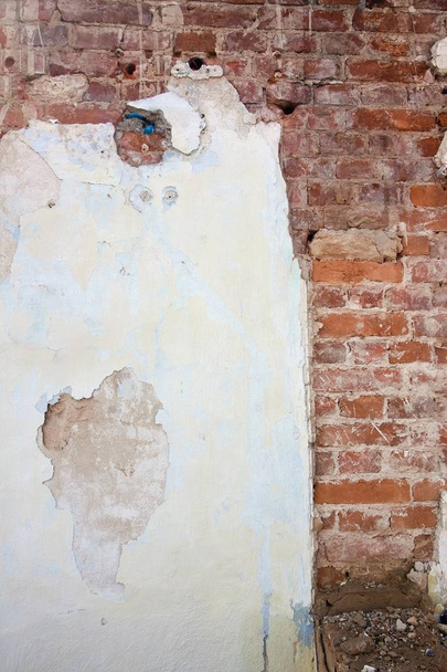 background of cracked plaster covered shabby old brick wall, vertical rough abstract surface texture photo - Photo, Image