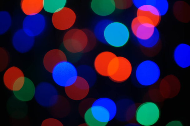 Многоцветная голубая праздничная гирлянда. Гарланд размыт. Много ярких круглых огней. Полностью разряженное фото. Размытый фон и передний план. Праздничное настроение Грядет Новый год и Рождество. - Фото, изображение